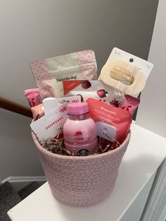 a pink basket filled with personal care items on top of a white counter next to a door