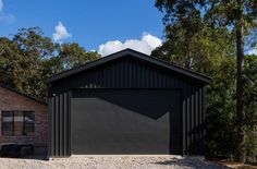 a black garage sits in front of a brick building