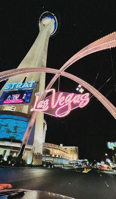 the las vegas sign is lit up at night with neon lights and buildings in the background