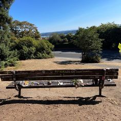 a wooden bench sitting on top of a dirt field