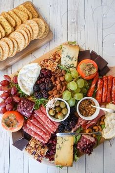 a platter filled with meats, cheeses and crackers