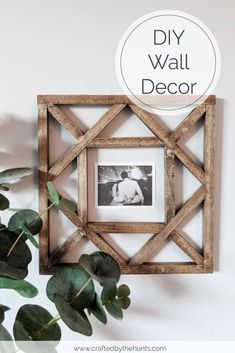 a wooden frame hanging on the wall next to a potted plant and a sign that says diy wall decor