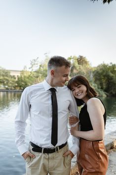 a man and woman standing next to each other near water