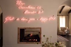 a living room filled with furniture and a fire place under neon signs on the wall