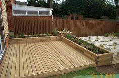 a wooden deck in the middle of a yard