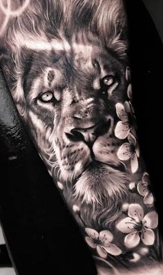 a black and white photo of a lion with flowers on it's arm