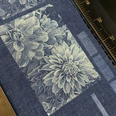 a piece of fabric with flowers printed on it next to a ruler and measuring tape