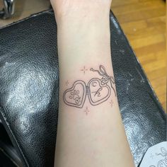 a tattoo on the wrist of a woman with two heart shaped cookies in it's hands