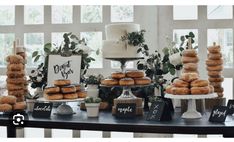 a table topped with lots of donuts next to a cake and cupcakes