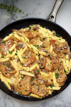 a skillet filled with pasta and mushrooms