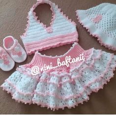 a crocheted baby outfit and booties are laying on the floor