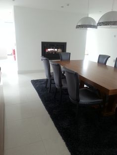 a dining room table and chairs with a fireplace in the backgroung area