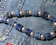 a pair of bracelets made out of jeans with pearls and beads on the clasp