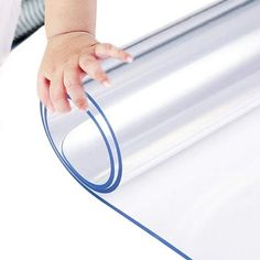 a baby's hand is on the edge of a roll of silver colored paper