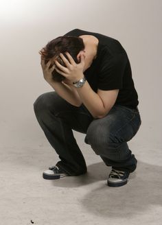 a man kneeling down with his head in his hands