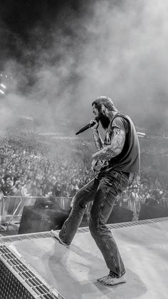 a man standing on top of a stage holding a microphone in front of an audience