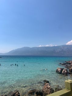 people are swimming in the clear blue water