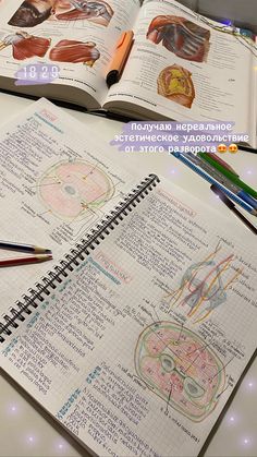 an open medical textbook on a table with markers and pencils in front of it