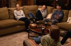 three people sitting on couches in a living room