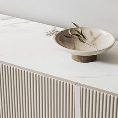 a white bowl sitting on top of a marble counter next to a radiator