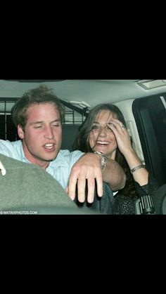 a man and woman sitting in the back seat of a car