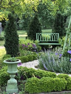 a green bench sitting in the middle of a garden