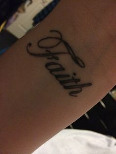 a person with a tattoo on their arm that reads,'faith'and has scissors in it