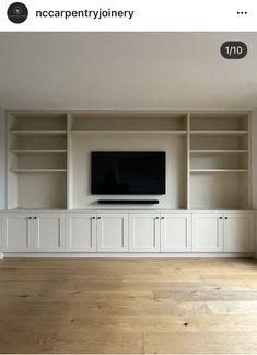 an empty living room with white cabinets and a flat screen tv