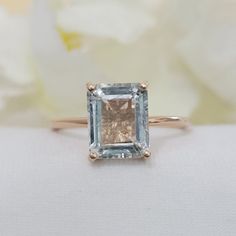 a ring with an aqua blue topazte surrounded by white flowers