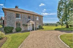 a large stone house with a driveway leading to it