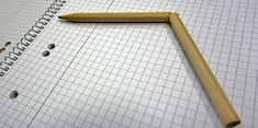 a pencil laying on top of a piece of paper next to holes in the graph paper