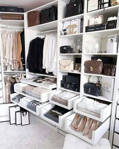 an organized closet with white shelving and handbags