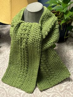 a green knitted scarf sitting on top of a table