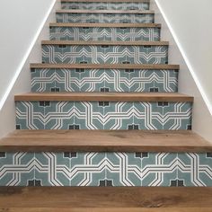 the stairs are painted with blue and white geometric designs on them, along with wood flooring