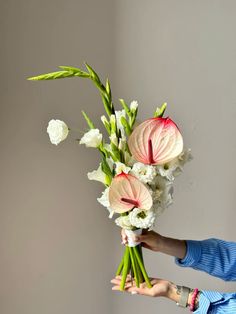 a woman holding a bouquet of flowers in her hands with the stems still attached to it