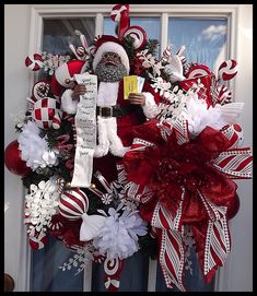 a christmas wreath with santa claus and candy canes on the front door for someone's house