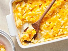 a casserole dish with cheese and a wooden spoon