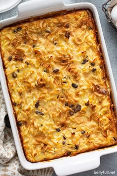 a casserole dish with cheese and mushrooms in it on a blue tablecloth