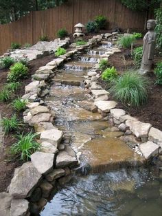 a garden with rocks and water flowing from it