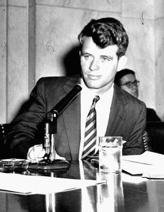 a man sitting at a table in front of a microphone