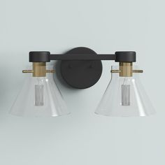 two light bathroom fixture with clear glass shades and black metal fittings on the wall