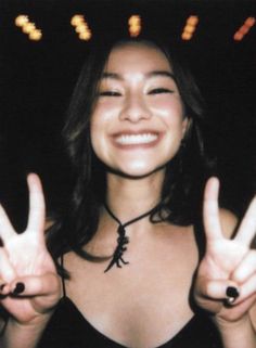 a woman making the peace sign with her hands