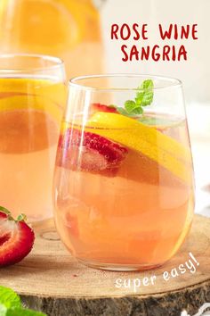 two glasses filled with rose wine sangria next to sliced strawberries