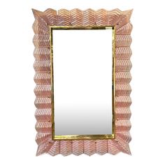 a pink and gold framed mirror sitting on top of a white wall