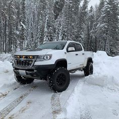 a white truck driving down a snow covered road