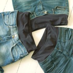 three pairs of jeans laid out on the floor