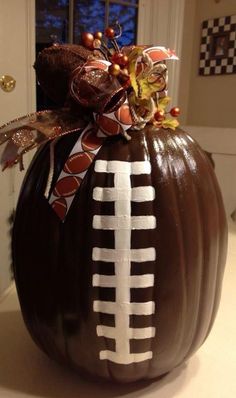 a decorated pumpkin with a football on it