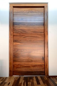 a wooden door in a room with white walls