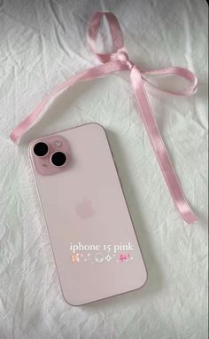 an iphone case with a pink ribbon attached to the front and back of it, laying on a white sheet