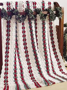 a crocheted blanket draped over a wooden bed frame with christmas decorations on it